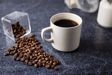 Coffee cup with coffee beans placed on a granite surface