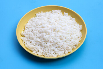 Fototapeta na wymiar Dish of rice on blue background.