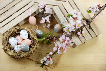 Fototapeta na wymiar Uova di Pasqua con nido e fiori di mandorlo