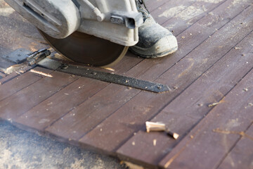A worker cuts the wood with a petrol saw