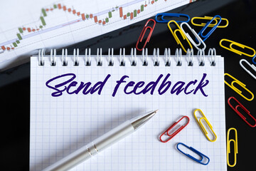 On the desktop are a forex chart, paper clips, a pen and a notebook in which it is written - Send feedback
