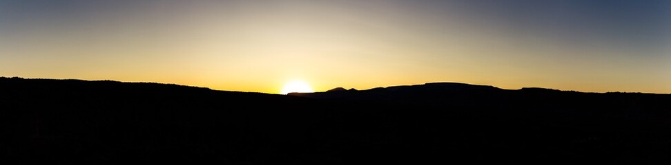 Panorama shot of sun on horizon at sunset in capitol reef national park in Utah, america