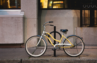 Yellow bicycle parked on city street at night