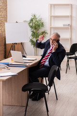 Old businessman employee sitting in the office