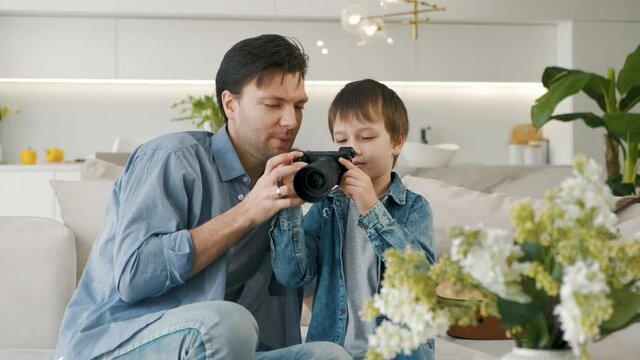 Father teaches his son to use camera at home