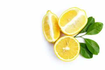 Fresh lemon with green leaves on white.