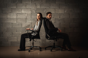 Bad relationship concept. Man and woman in disagreement. Young couple after a quarrel sitting on chairs back to back. Businessmen and partners did not share anything 