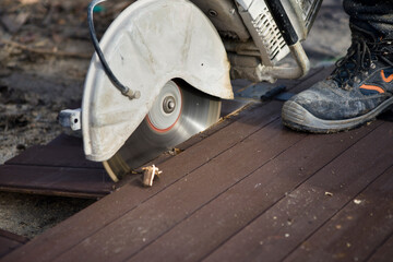 A worker cuts the wood with a petrol saw