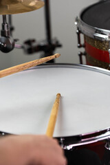 Professional drum set closeup. Man drummer with drumsticks playing drums and cymbals, on the live music rock concert or in recording studio   