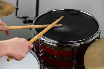 Professional drum set closeup. Man drummer with drumsticks playing drums and cymbals, on the live music rock concert or in recording studio   