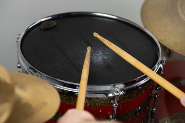 Professional drum set closeup. Man drummer with drumsticks playing drums and cymbals, on the live music rock concert or in recording studio   
