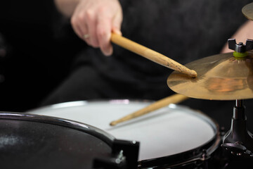 Professional drum set closeup. Man drummer with drumsticks playing drums and cymbals, on the live music rock concert or in recording studio   