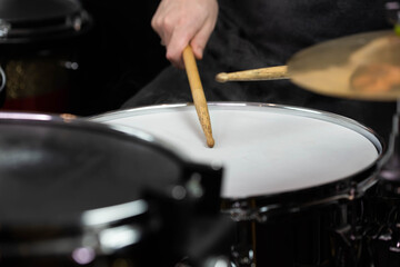Professional drum set closeup. Man drummer with drumsticks playing drums and cymbals, on the live music rock concert or in recording studio   