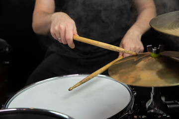 Professional drum set closeup. Man drummer with drumsticks playing drums and cymbals, on the live music rock concert or in recording studio   