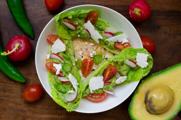 Breakfast of eggs and avocado on a wooden table.