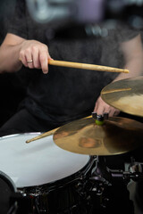 Professional drum set closeup. Man drummer with drumsticks playing drums and cymbals, on the live...