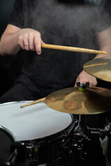 Professional drum set closeup. Man drummer with drumsticks playing drums and cymbals, on the live music rock concert or in recording studio   