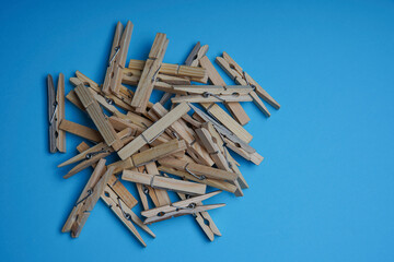 Wooden clothespin isolated on a blue background. The clothespin is a fastener used to dry clothes.
