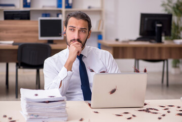 Young male employee and too many cockroaches in the office