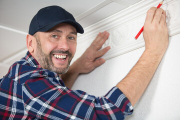 happy male plaster working on stucco relief