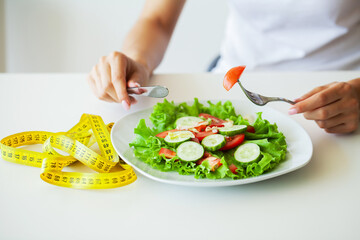 Closeup of fresh salad in a bowl and yellow measure tape