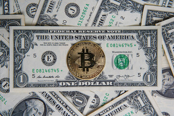Pile of American one dollar cash. Next to it are several gold bitcoin digital cryptocurrency coins. Bank image and photo background.