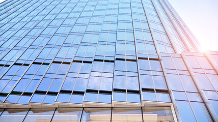 Downtown corporate business district architecture. Glass reflective office buildings against blue sky and sun light. Economy, finances, business activity concept. Rising sun on the horizon.