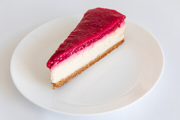 Close up of Cheesecake slice on a white plate. Raspberry cheesecake. Copy space. selective focus