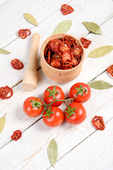 Closeup Dried cherry tomatoes from above on a wooden background, cut slices and whole tomatoes.