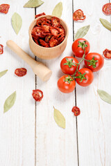 Closeup Dried cherry tomatoes from above on a wooden background, cut slices and whole tomatoes.