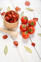 Closeup Dried cherry tomatoes from above on a wooden background, cut slices and whole tomatoes.