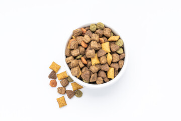 domestic animals dry food at white bowl isolated on white background. dried cat feed cut out. above view