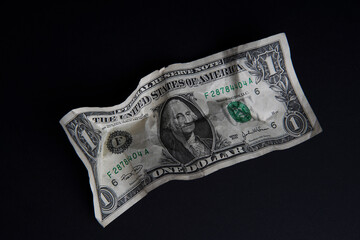 Financial crisis, crumpled one dollar banknote, US dollars on the black table. Bank image and commercial photo background.