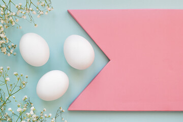 Three white chicken eggs with flowers with a copy of the space. Branding