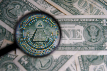 US dollar viewed through a magnifying glass, close up detail of the pyramid. Masonic symbols. Bricklayer signs on the dollar: All-seeing eye, pyramid. Bank image and commercial photo background.