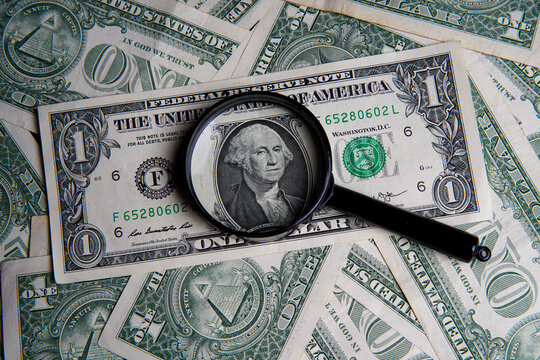 US one dollar viewed through a magnifying glass, close up portrait of the late George Washington, first president of the United States. Bank image and commercial photo background.