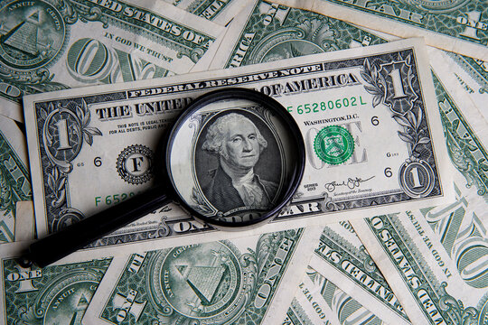 US one dollar viewed through a magnifying glass, close up portrait of the late George Washington, first president of the United States. Bank image and commercial photo background.