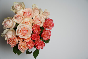 Beautiful white, red, tabby tea rose flowers in a vase, photographed from above on a white table. Spring flowers. Wedding mothers day and valentines day background. Selective small depth of field.