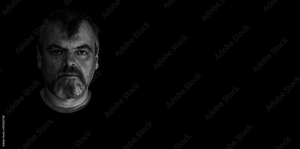 Wall mural portrait of adult angry bearded man on black background