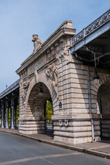 View of Pont de Bir-Hakeim (formerly pont de Passy) - a bridge that crosses the Seine River in Paris. Central arch decorated with monumental statues. France.