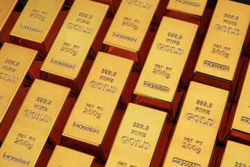 Gold bars next to each other on a black background. Shiny precious metal for investment or as a reserve. Place for text.