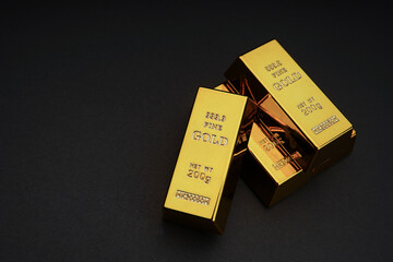 a pile of gold bar on a black background. Shiny precious metals for investments or reserves. Place...