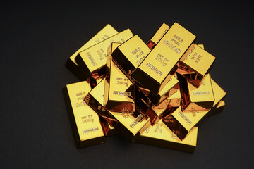 A pile of gold bar a black background. Shiny precious metals for investments or reserves.