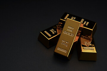 A pile of gold bar a black background. Shiny precious metals for investments or reserves.