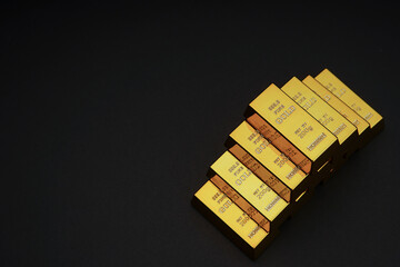 a pile of gold bar on a black background. Shiny precious metals for investments or reserves. Place...