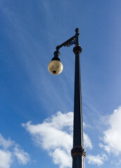 Street lamp against blue sky