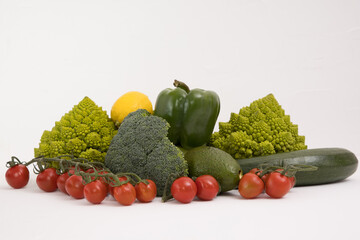 Healthy vegetarian food, fresh green food, green vegetable, romanesco broccoli, pepper, zucchini, avocado, cherry tomato and lemon, free space in your text, on a isolated background