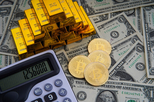 Gold bars with calculator on dollar bills background and bitcoin digital cryptocurrency coin. Bank image and photo background. Money saving investment.