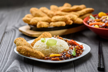 rice with vegetables in sweet and sour sauce and chicken tenderloin