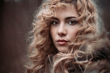 Close-up portrait of a young woman with blonde curly hair
